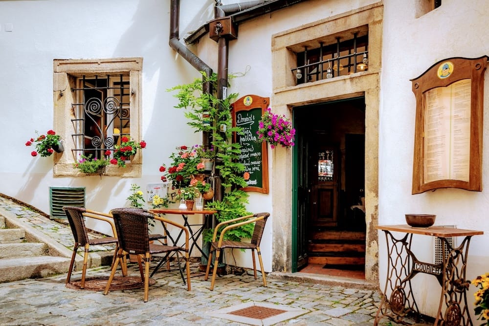 cesky-krumlov-courtyard-cafe Traditional café with outdoor seating on a cobbled street in Český Krumlov's historic old town