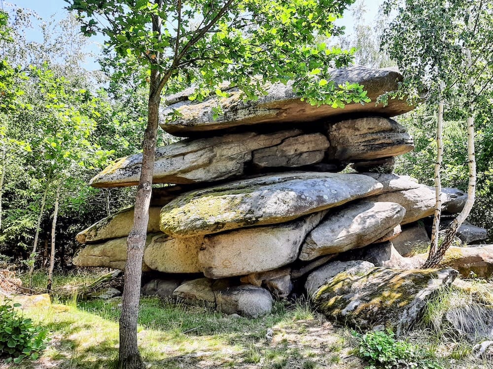 The massive, stacked granite boulders of the Velký čertův náramek (The Big Devil’s Bracelet) rock formation nestled in a sunny birch and oak forest near Blatná